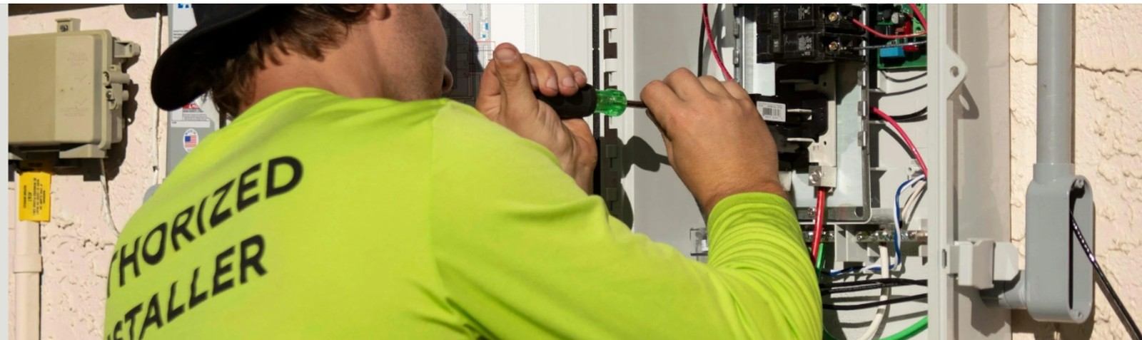 Electrician terminating conductors inside an exterior service panel